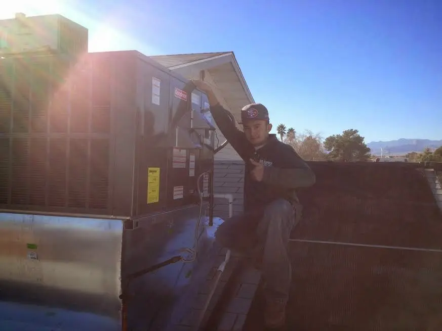 HVAC technician performing AC Tune-Up on a rooftop unit in Cold Spring